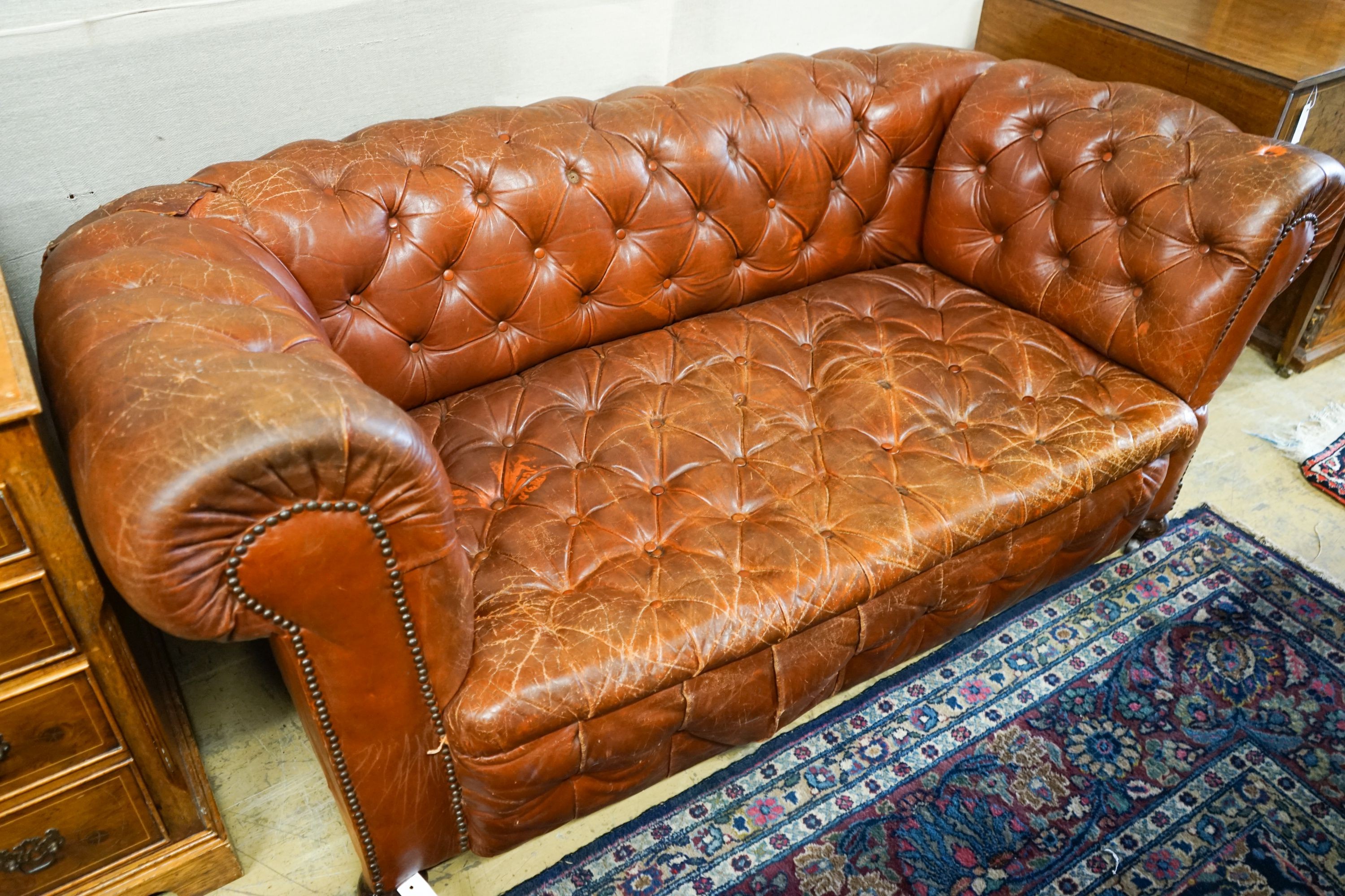 A late Victorian drop arm leather button back Chesterfield settee, length 170cm, depth 88cm, height 70cm